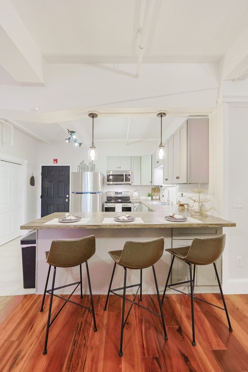 148 Bernon Street, Unit 19 Woonsocket, RI 02895 - Photo 5 of 20 a kitchen with stainless steel appliances kitchen island a table and chairs in it