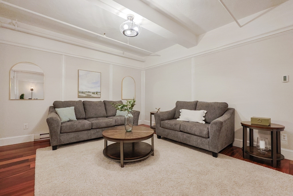 148 Bernon Street, Unit 19 Woonsocket, RI 02895 - Photo 7 of 20 a living room with furniture and a wooden floor