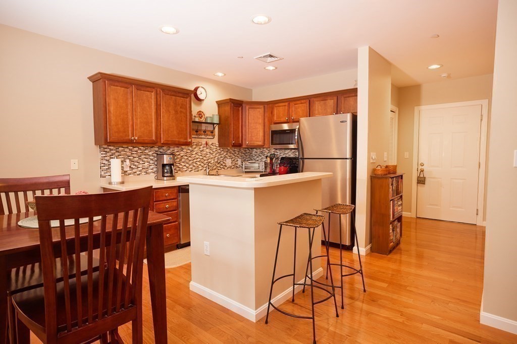 974 Main Street, Unit 34 Wakefield, MA 01880 - Photo 5 of 15 a kitchen with stainless steel appliances kitchen island granite countertop a refrigerator and a stove top oven