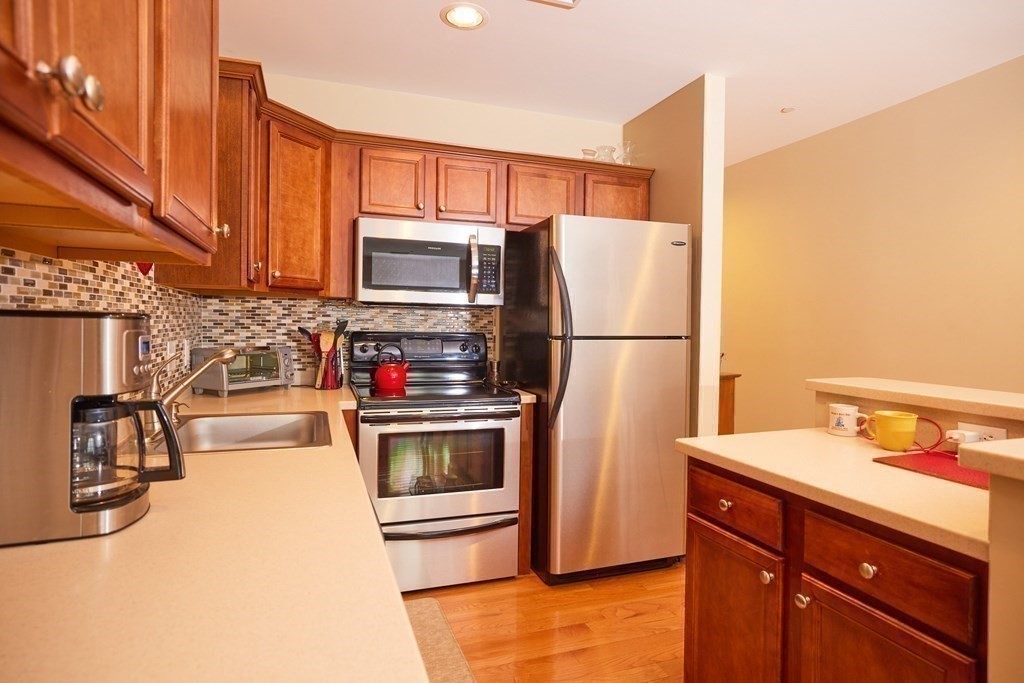974 Main Street, Unit 34 Wakefield, MA 01880 - Photo 6 of 15 a kitchen with stainless steel appliances a refrigerator and a stove top oven