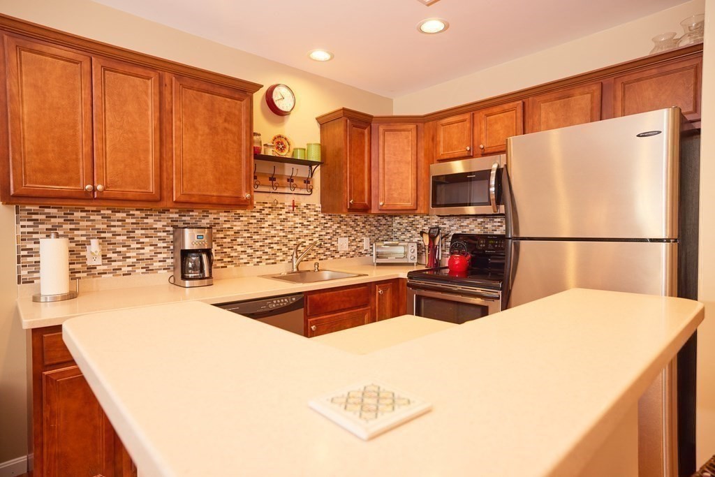974 Main Street, Unit 34 Wakefield, MA 01880 - Photo 7 of 15 a kitchen with a sink a stove and a refrigerator