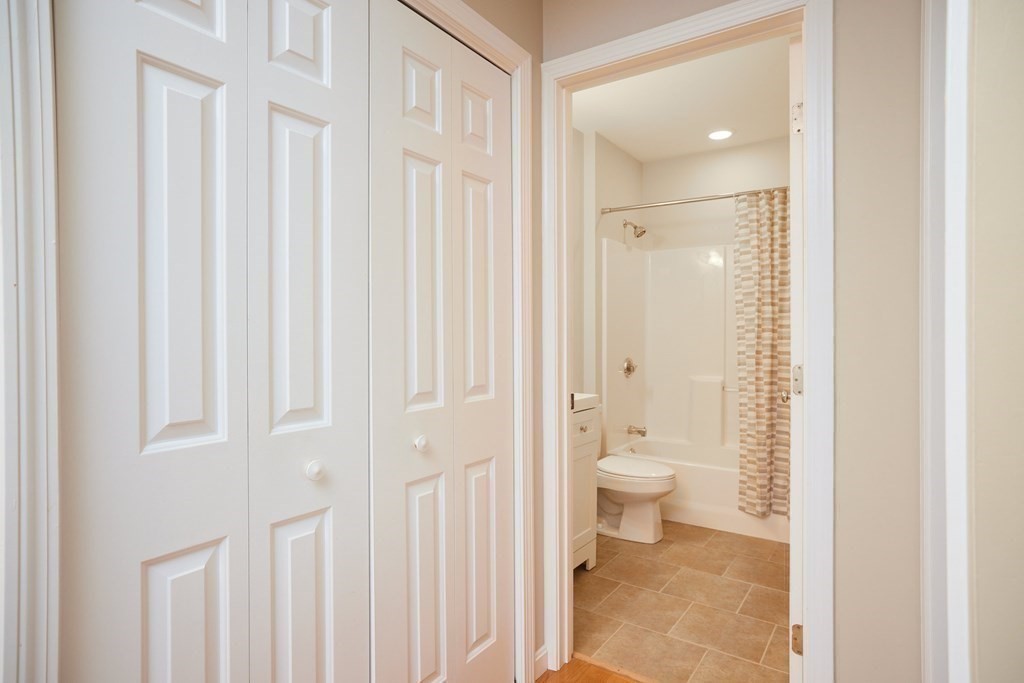 974 Main Street, Unit 34 Wakefield, MA 01880 - Photo 8 of 15 a bathroom with a granite countertop toilet a sink and a mirror