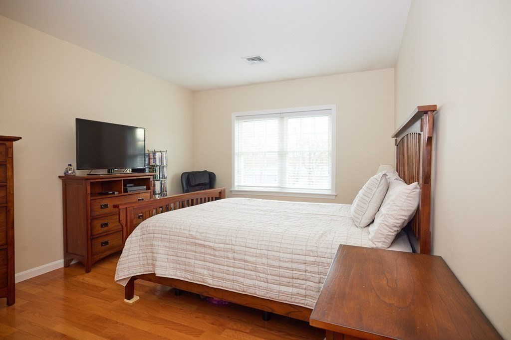 974 Main Street, Unit 34 Wakefield, MA 01880 - Photo 10 of 15 a bedroom with a bed and wooden floor