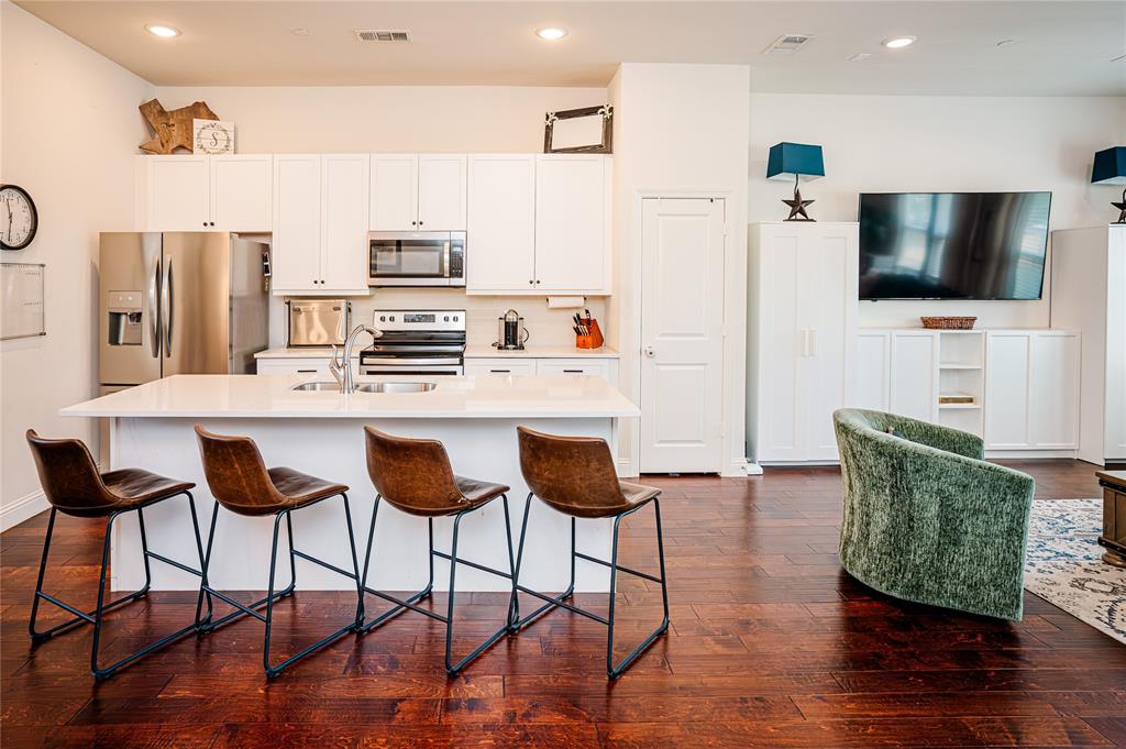 a kitchen with stainless steel appliances kitchen island granite countertop a refrigerator a stove a microwave oven with a dining table and chairs