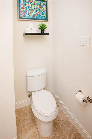 a white toilet sitting next to a white wall