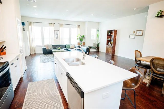 a kitchen with stainless steel appliances a stove a sink and cabinets