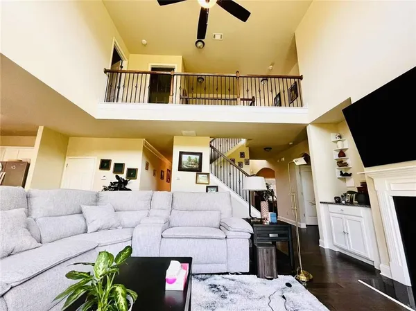 a living room with furniture a flat screen tv and kitchen view