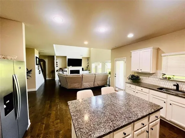 a large kitchen with a sink stainless steel appliances and furniture