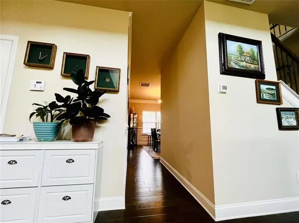a view of a hallway with wooden floor and flat screen tv