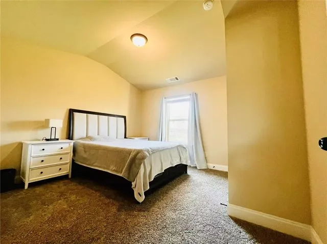 a spacious bedroom with a bed and cabinets