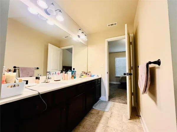 a en suite bathroom with a double vanity sink and mirror