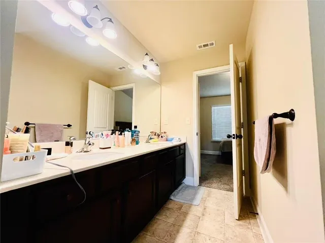 a en suite bathroom with a double vanity sink and mirror