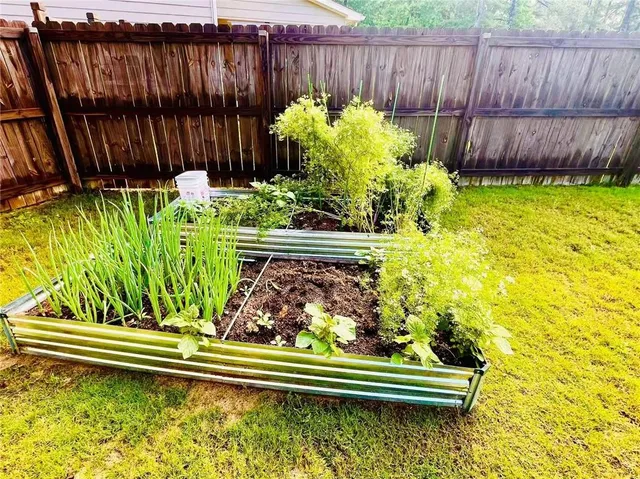 a view of garden with wooden fence