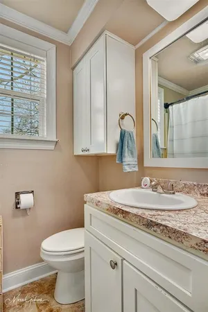 a bathroom with a granite countertop toilet sink and mirror