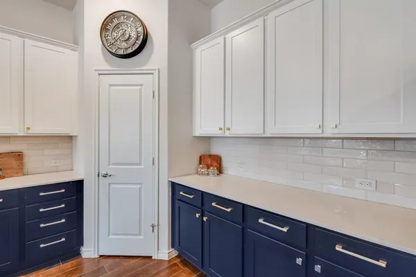 a kitchen with a cabinets and a clock on the wall