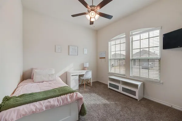 a bedroom with a bed and a tv on the dresser