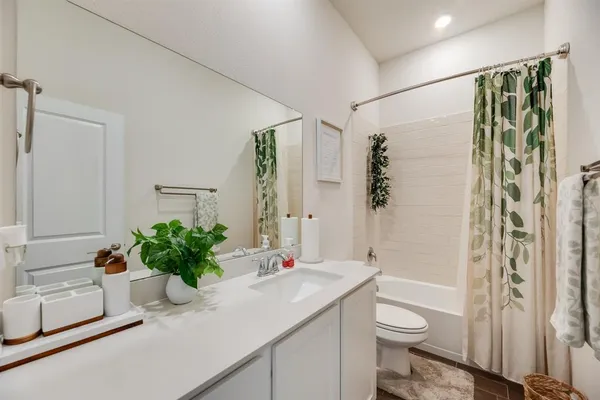 a bathroom with a granite countertop sink a toilet and shower