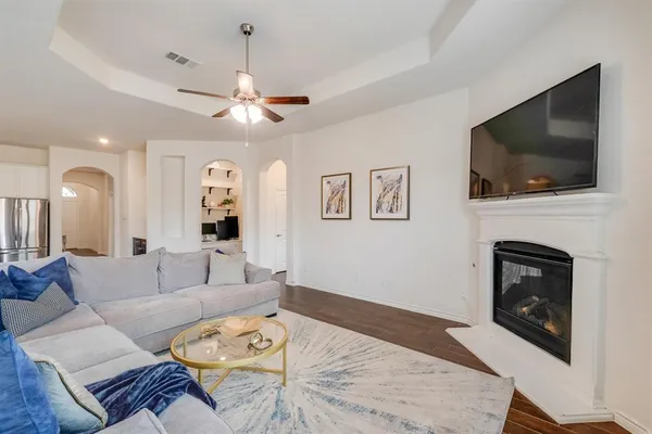 a living room with furniture a flat screen tv and a fireplace