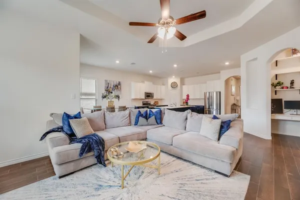 a living room with furniture and a view of kitchen