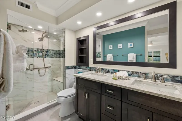 a bathroom with a double vanity sink toilet and shower