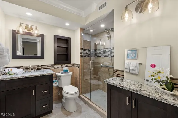 a bathroom with a granite countertop toilet sink and mirror