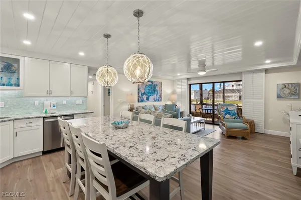 a very nice looking kitchen with granite countertop a stove two sinks and a wooden floor