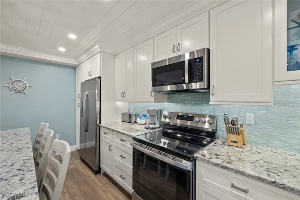 a kitchen with stainless steel appliances granite countertop a refrigerator stove a sink dishwasher and microwave oven