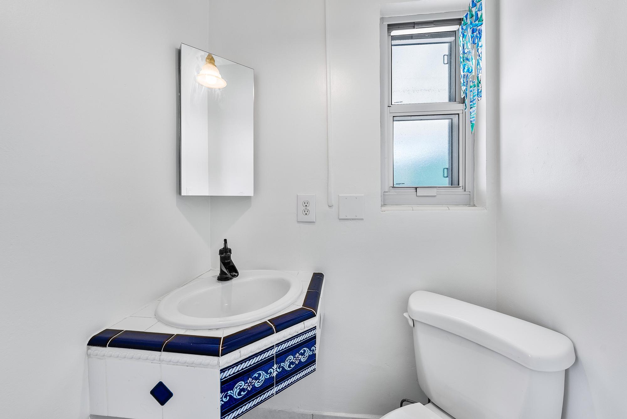 445 Monroe Drive West Palm Beach, FL 33405 - Photo 12 of 20 a bathroom with a toilet a sink and mirror