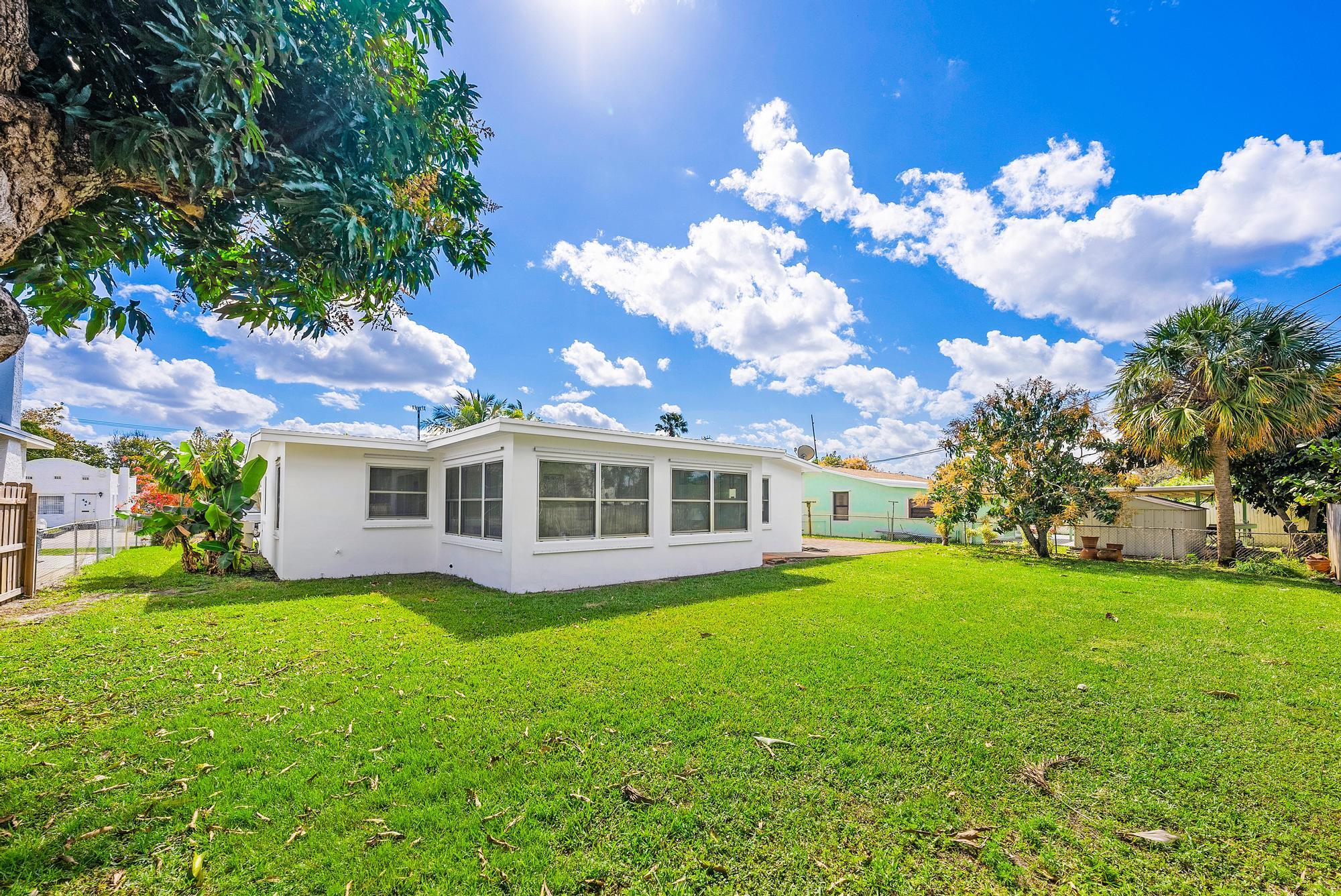 445 Monroe Drive West Palm Beach, FL 33405 - Photo 13 of 20 a view of a house with a big yard and potted plants