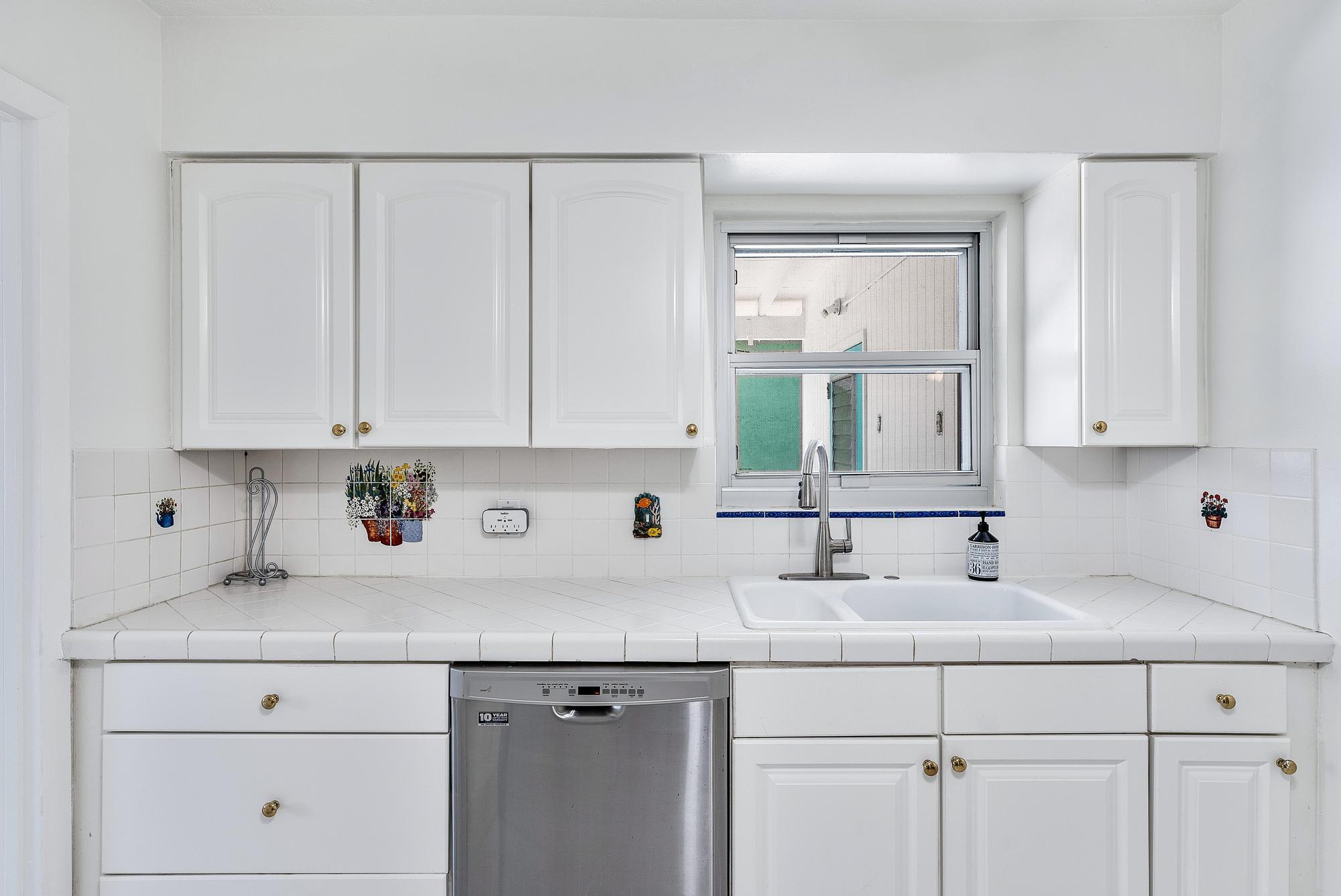445 Monroe Drive West Palm Beach, FL 33405 - Photo 15 of 20 a kitchen with white cabinets and a sink