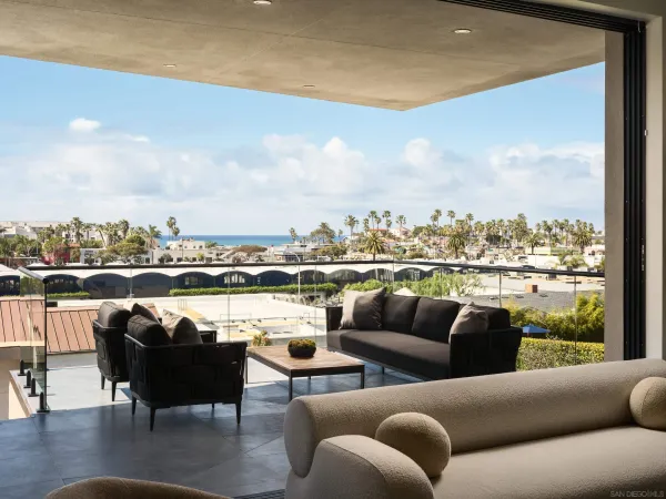 a roof deck with couches and ocean view