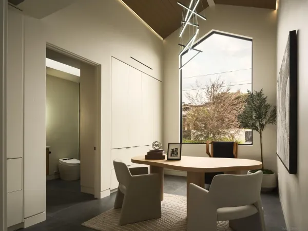 a room with a table chairs and a view of kitchen