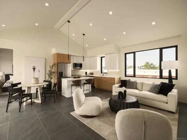 a living room with furniture kitchen and a large window