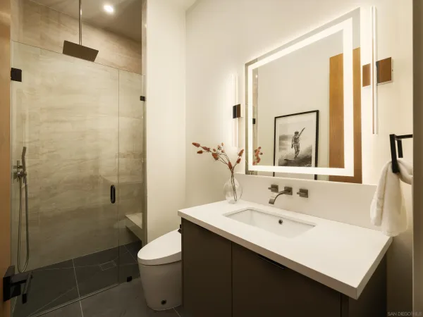 a bathroom with a sink a toilet and shower