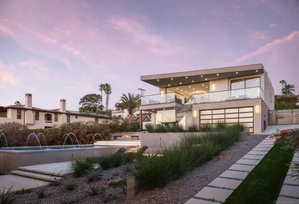 a view of a house with a yard and potted plants