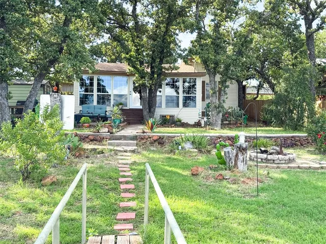 a front view of a house with a yard table and chairs