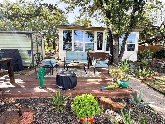 a view of a patio with table and chairs potted plants and a large tree