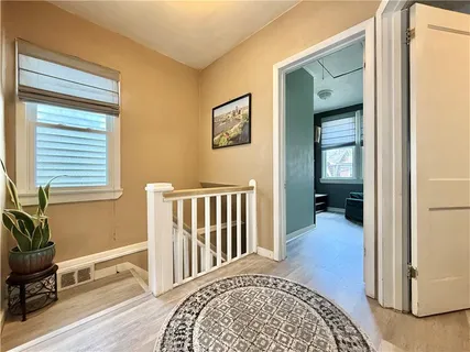 a view of a bedroom with wooden floor & a window