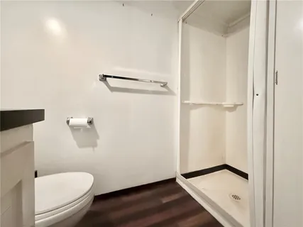 a bathroom with a granite countertop toilet and a sink