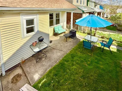 a view of a patio with chairs and table under an umbrella