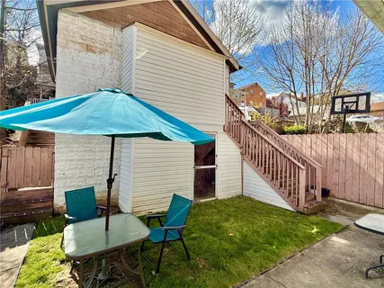 a view of a chair and table in backyard