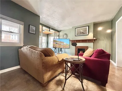 a living room with fireplace furniture and a window