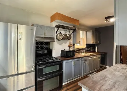 a kitchen with stainless steel appliances a stove a sink and a refrigerator