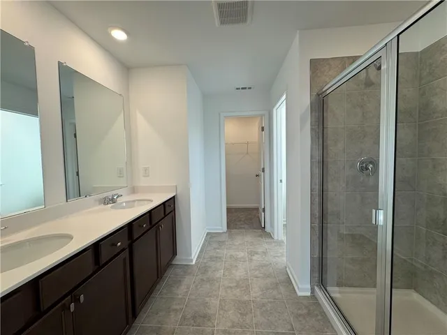 a spacious bathroom with a shower sink and mirror