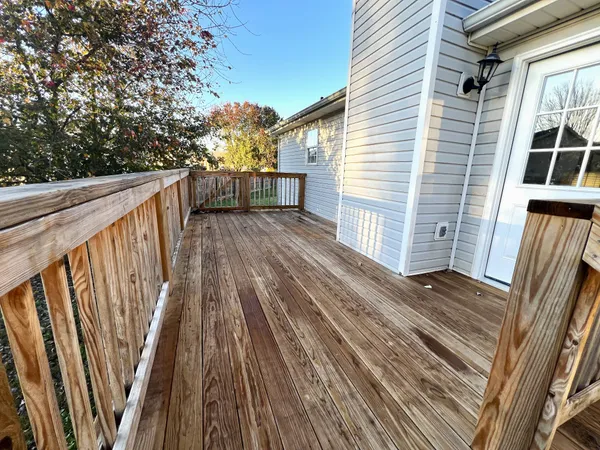 a view of backyard with wooden floor and fence