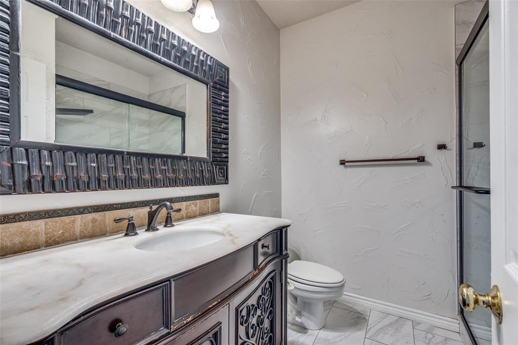3421 Neiman Road Plano, TX 75025 - Photo 21 of 40 Full bathroom featuring a stall shower, vanity, and marble look tiles