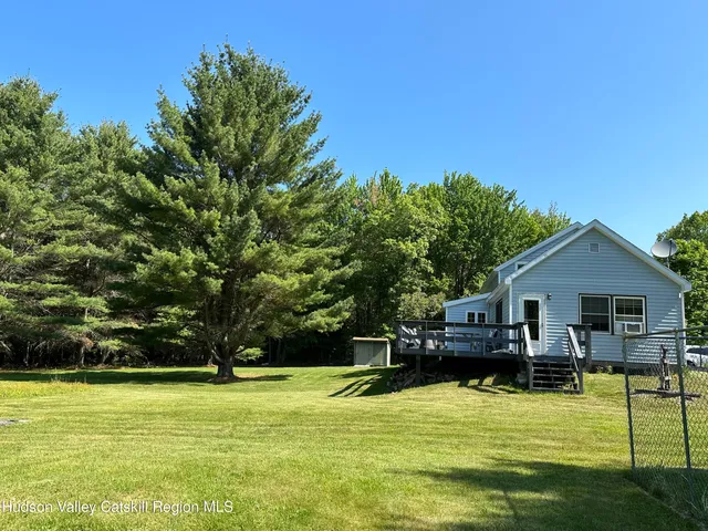 a front view of a house with a yard and trees