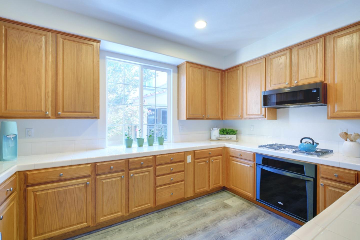 738 Claridad Loop Milpitas, CA 95035 - Photo 16 of 53 a kitchen with stainless steel appliances granite countertop white cabinets a sink and dishwasher with wooden floor