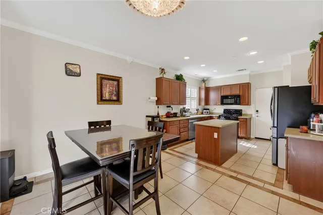 a kitchen with a dining table chairs and a refrigerator