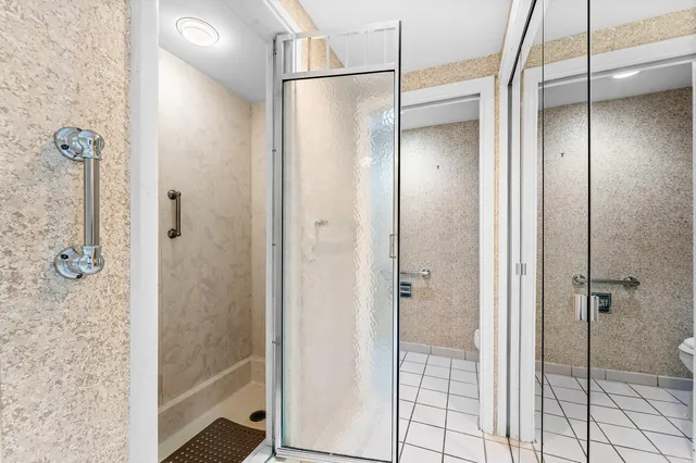 a bathroom with a glass shower door and a bathroom